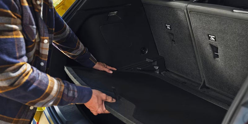 man putting something in trunk of chevy trailblazer
